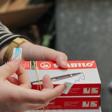 Aufkleben von Etiketten auf Waren | © 2024 Lehrberufe | Woche-Pass AG