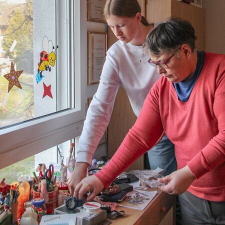 Einer Bewohnerin beim Aufräumen des Zimmers helfen | © 2024 Lehrberufe | Woche-Pass AG