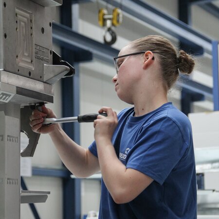 Polymechanikerin befestigt das Werkstück mit einer Schraube | © 2023 Lehrberufe | Woche-Pass AG